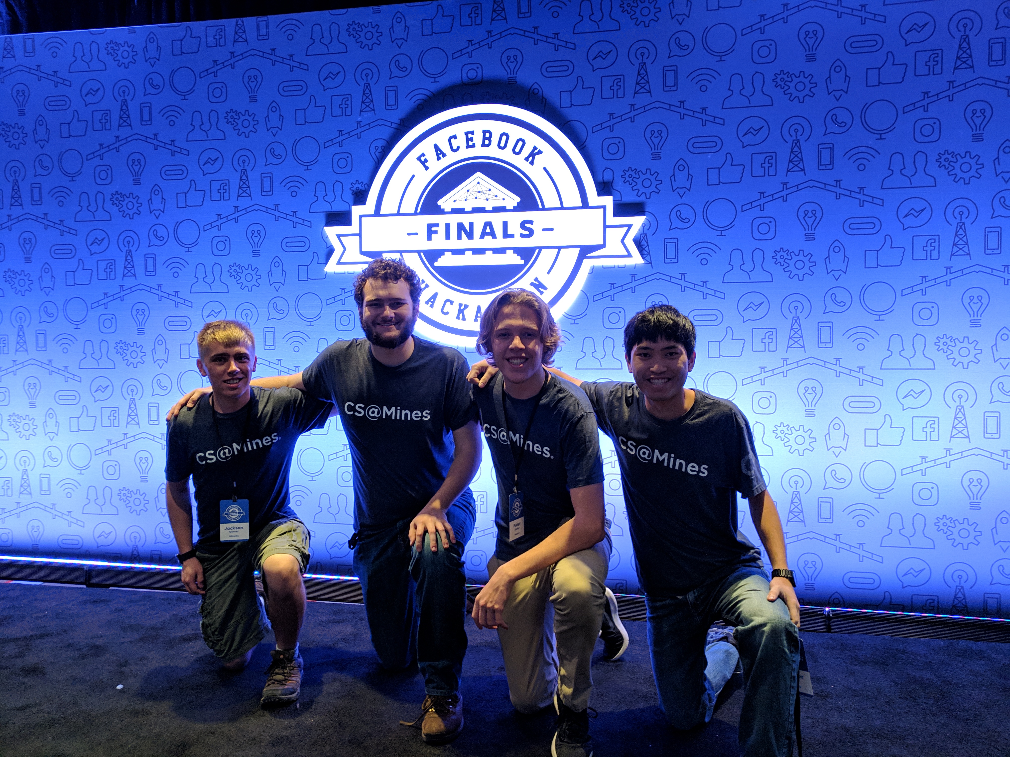 picture of the team on the front stage in front of the Facebook Global Hackathon Finals logo