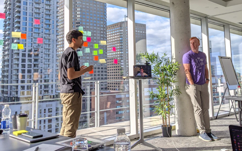 Brad looks on as Tulir discusses topics during our team retro.