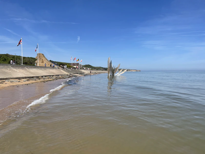 The sculpture in the water is in the shape of knives and depending on the tide is either partially submerged or entirely exposed. It has a dual meaning. It represents the violence of the battle and it also represents the lives cut short by the war.
The monument above the sea wall commemorates the American troops who landed at Omaha to begin the liberation of Europe.
