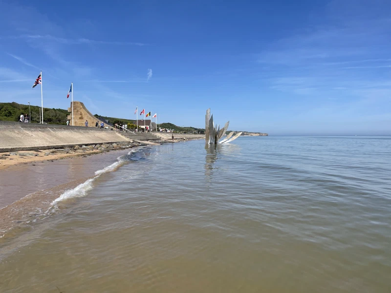 The sculpture in the water is in the shape of knives and depending on the tide is either partially submerged or entirely exposed. It has a dual meaning. It represents the violence of the battle and it also represents the lives cut short by the war.
The monument above the seawall commemorates the American troops who landed at Omaha to begin the liberation of Europe.
