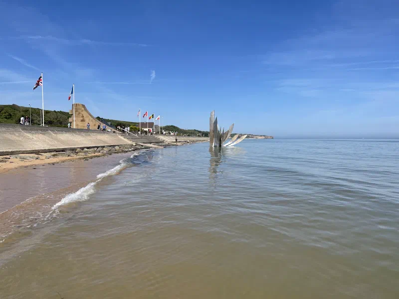 The sculpture in the water is in the shape of knives and depending on the tide is either partially submerged or entirely exposed. It has a dual meaning. It represents the violence of the battle and it also represents the lives cut short by the war.
The monument above the seawall commemorates the American troops who landed at Omaha to begin the liberation of Europe.